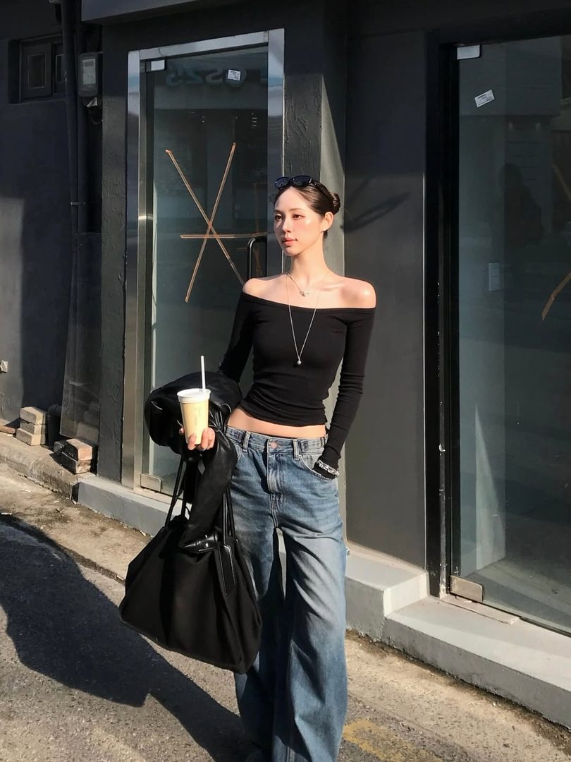 Editorial street-style portrait of a woman in an off-shoulder black top and wide-leg jeans — Fine Girls Telegram channel